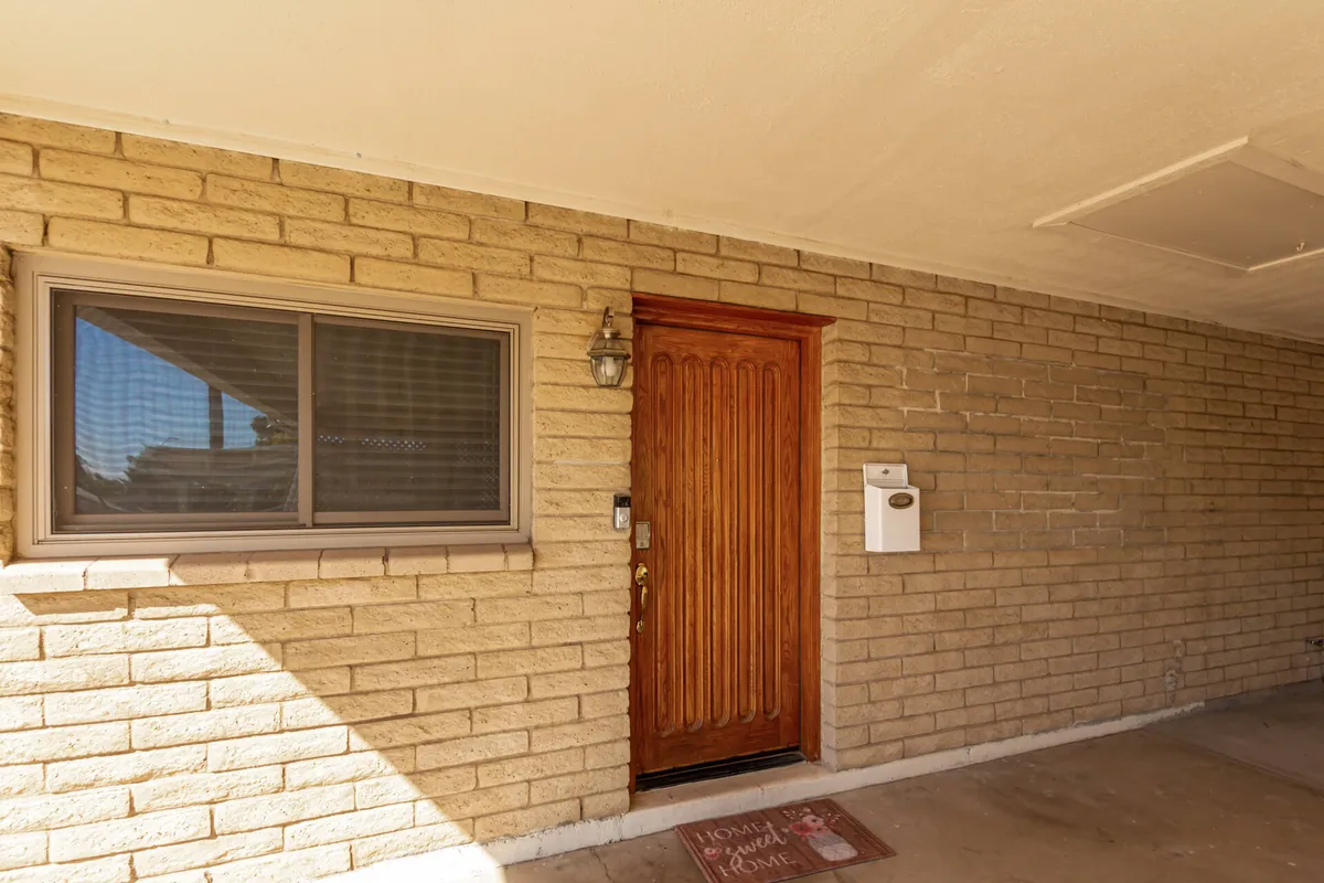 The front entrance of the home features a welcoming wooden door and a window, with a cheerful welcome mat. Seasonal decorations create an inviting, homey vibe, perfect for first-time arrivals or returning guests.